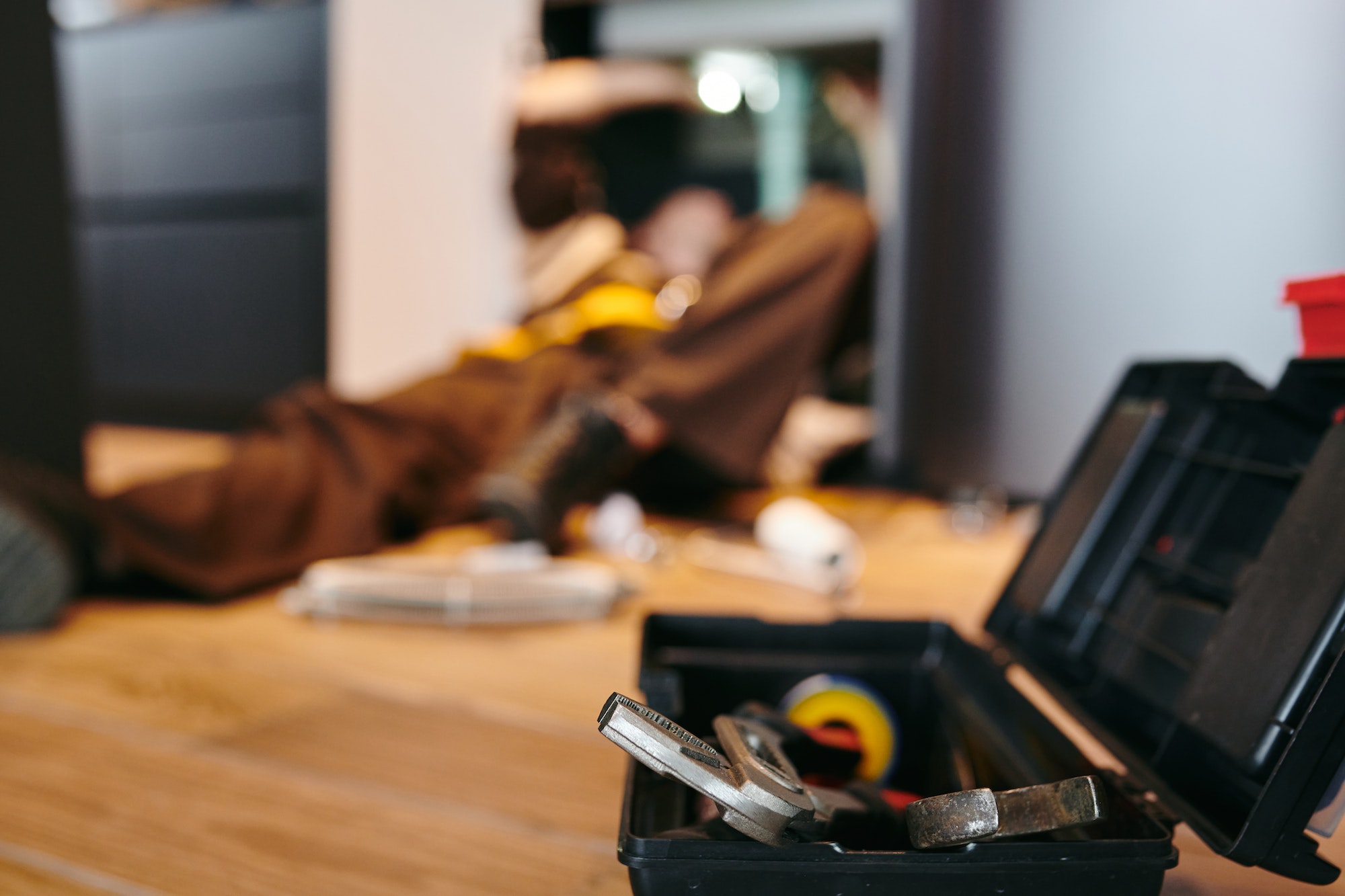 Toolbox with repairment handtools against plumber working